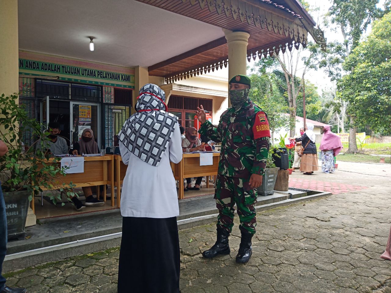 Warga Penerima Bankeu Di Kantor Lurah Labui Di Dampingi Oleh Personel Kodim 0301/Pekanbaru