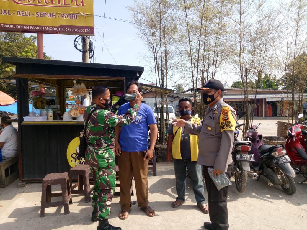 Cegah Penyebaran Covid-19, Babinsa Kodim 0301/PBR Bagikan Ratusan Masker Gratis di Pasar Tangor