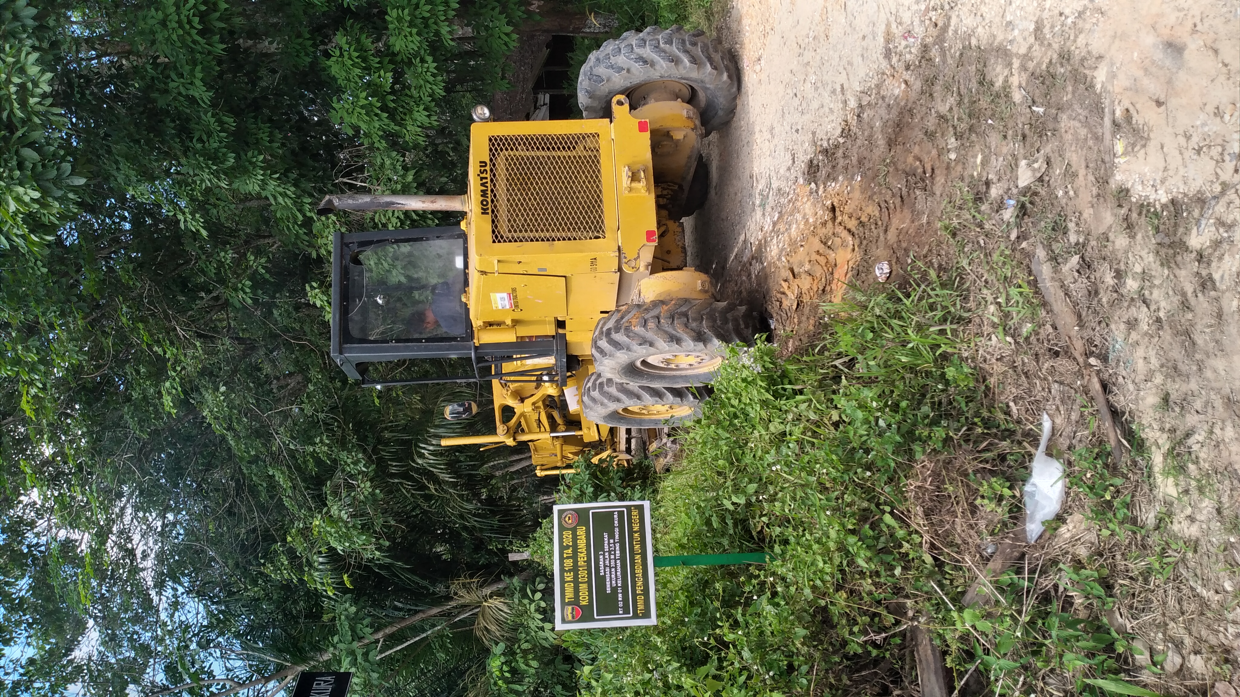 Satu Unit Alat Berat Sedang Bekerja Membentuk Badan Jalan Sekolah Pada Sasaran 3 TMMD Ke 108