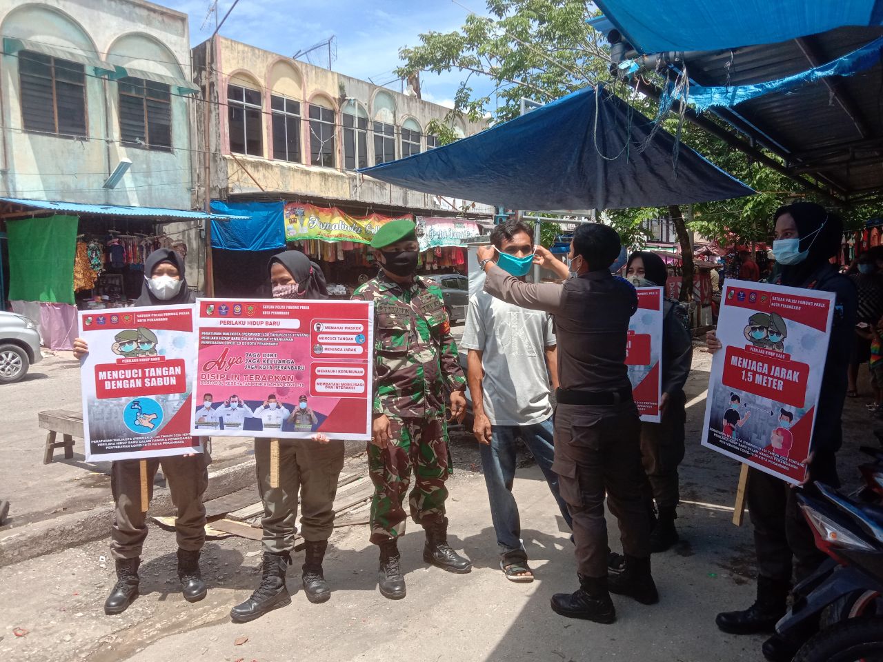 Babinsa Kodim 0301/PBR Bersama Personil Satpol PP Kota Bagikan Masker Kepada Pengunjung dan Pedagang di Pasar Kodim