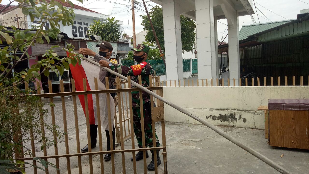 Personil Kodim 0301/PBR Bersama Bhabinkamtibmas Memasang Bendera Merah Putih Dirumah Warga