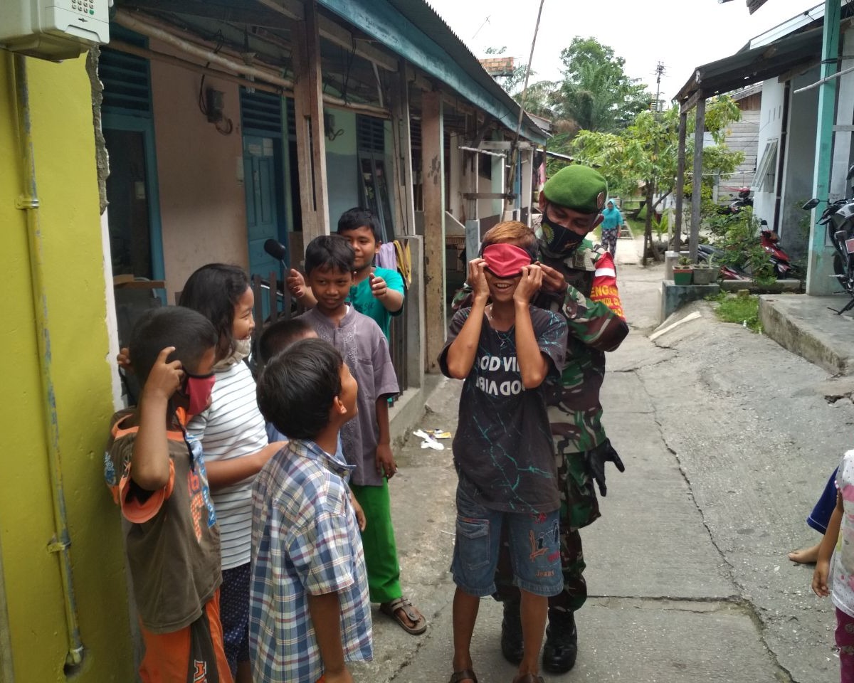 Peduli Kesehatan Warga, Babinsa Kodim 0301/PBR Bagikan Masker di Wilayah Binaan