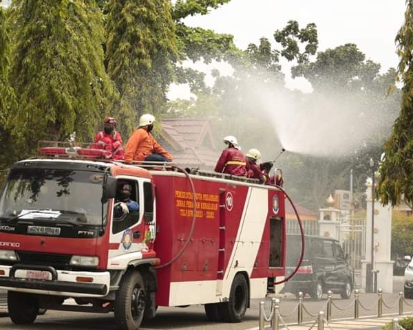 Pemko Pekanbaru Kerahkan 7 Unit Mobil Damkar Untuk Melakukan Penyemprotan Disinfektan di Jalan dan Perkantoran