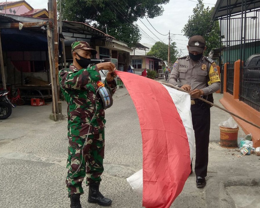 Personil Kodim 0301/PBR Bersama Bhabinkamtibmas Memasang Bendera Merah Putih Dirumah Warga