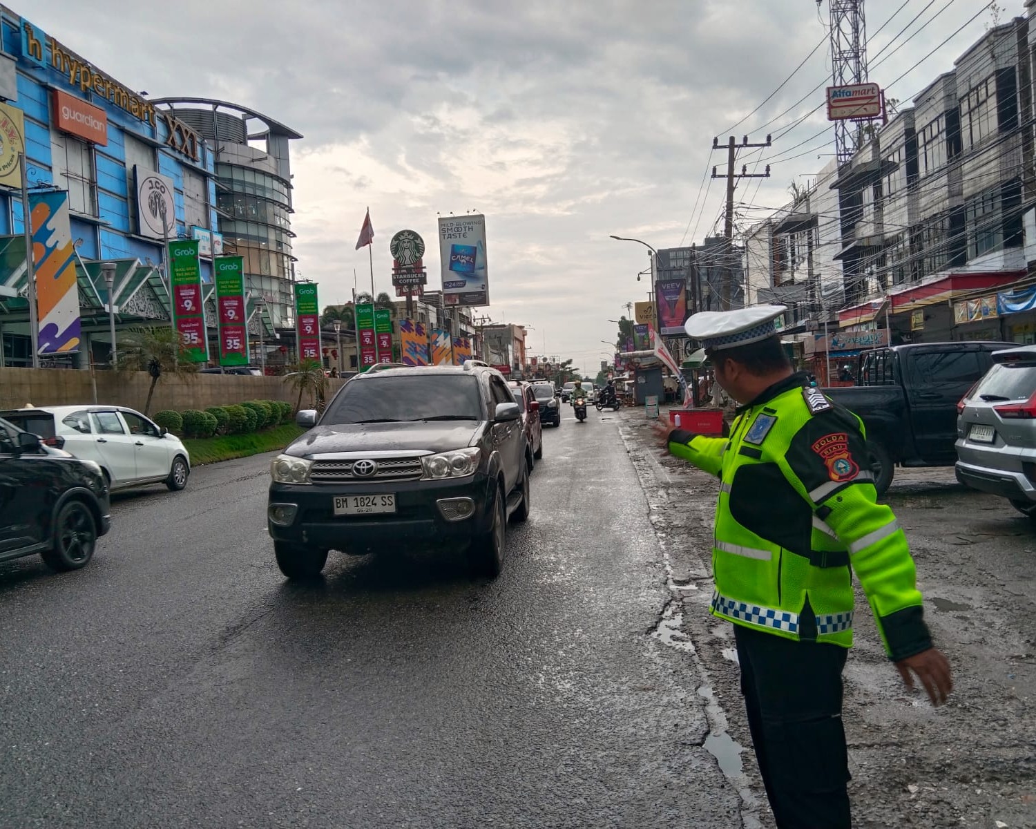 Diguyur Hujan, Personel Ditlantas Polda Riau Dan Satlantas Polresta Pekanbaru Tetap Fokus Urai Kemacetan