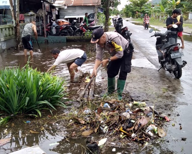 Aipda Toha Bhabinkamtibmas Kelurahan Menteng Polsek Pahandut Turun Langsung Bersama Warga Jalan G.Obos V, Untuk Membersihkan Drainase