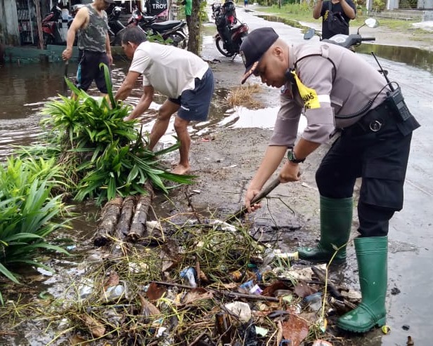 Aipda Toha Bhabinkamtibmas Kelurahan Menteng Polsek Pahandut Turun Langsung Bersama Warga Jalan G.Obos V, Untuk Membersihkan Drainase