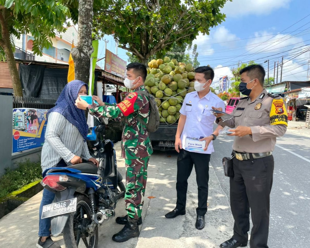 Babinsa Kodim 0301/PBR Laksanakan Himbauan Prokes dan Bagikan Masker di Tempat Perbelanjaan Kelurahan Delima