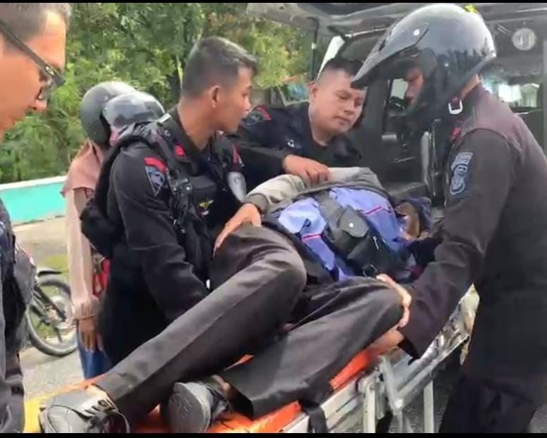 Saraf Terjepit Kambuh, Seorang Warga Terkapar Di Pinggir Jalan Dibantu Personel Brimob Polda Riau