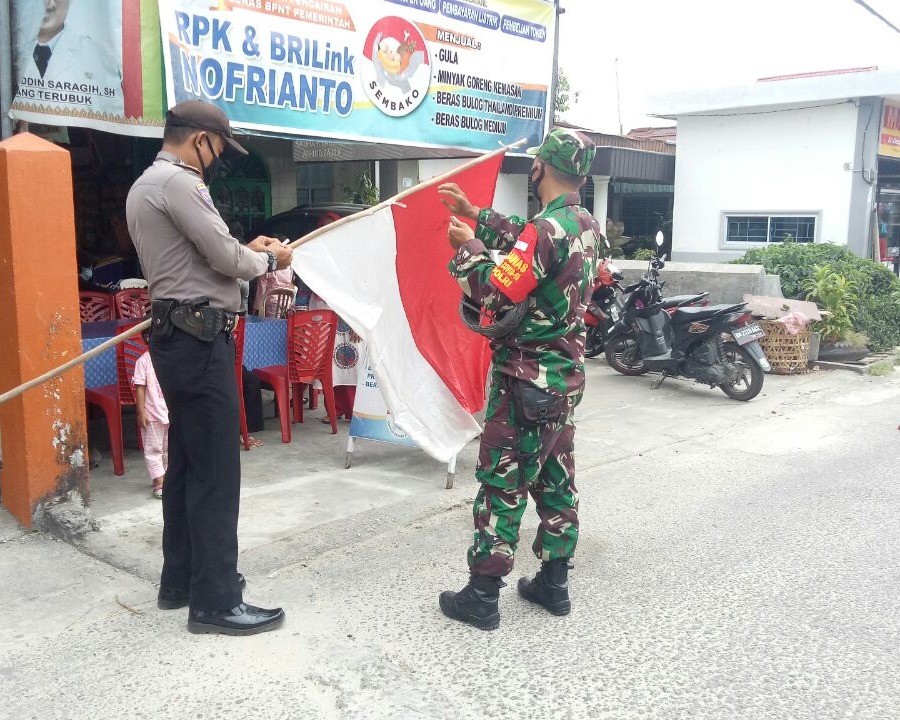 Personil Kodim 0301/PBR Bersama Bhabinkamtibmas Memasang Bendera Merah Putih Dirumah Warga