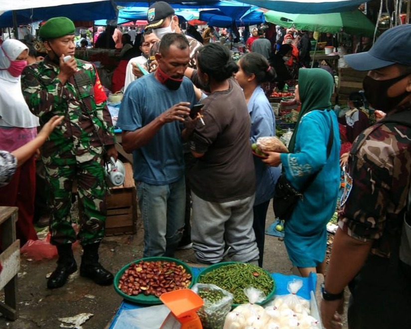 Personil Kodim 0301/PBR Bersama GM FKPPI Riau Laksanakan Kegiatan Bagi Masker Gratis di Pasar Cik Puan